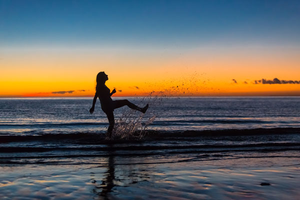 Mujer disfrutando un amanecer en el mar